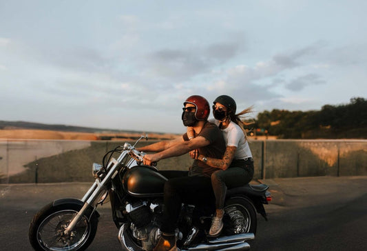 Couple qui roule décontracté à moto équipé de casques vintages. Mais sont ils homologués ces casques ?